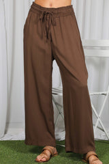 woman wearing brown wide-leg pants with an elastic waistband and drawstring detail