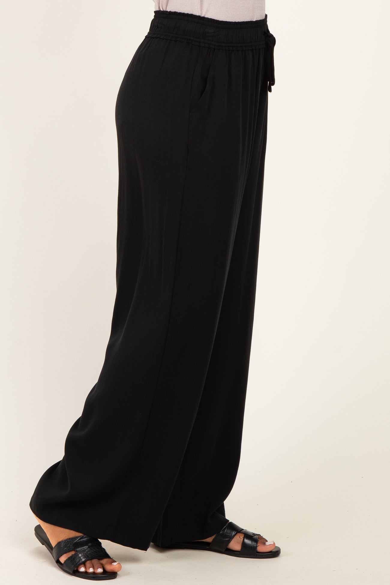 woman wearing black wide-leg pants with an elastic waistband and drawstring detail