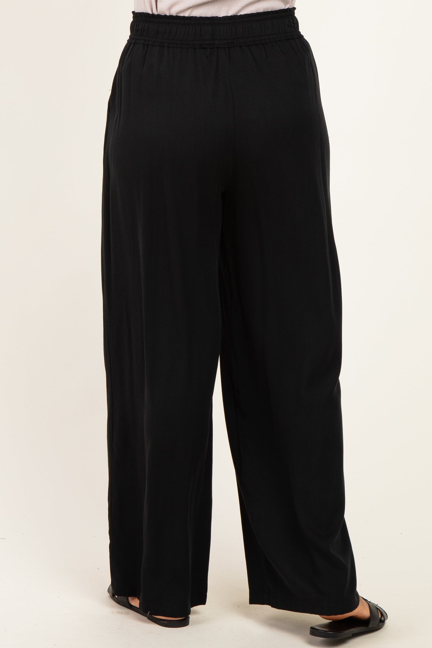 woman wearing black wide-leg trousers with an elastic waistband, shown from the back