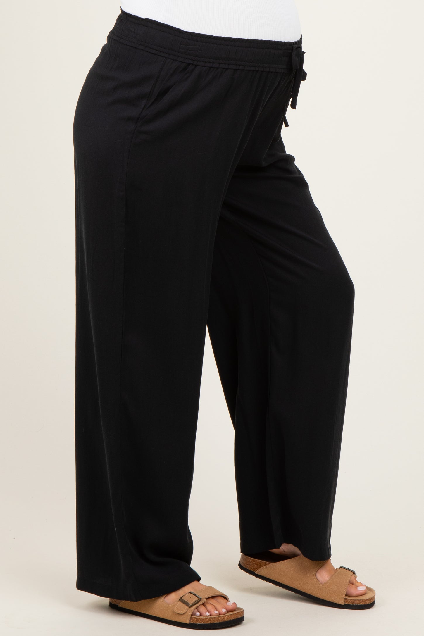woman wearing black maternity wide-leg pants with a drawstring waist and a visible baby bump