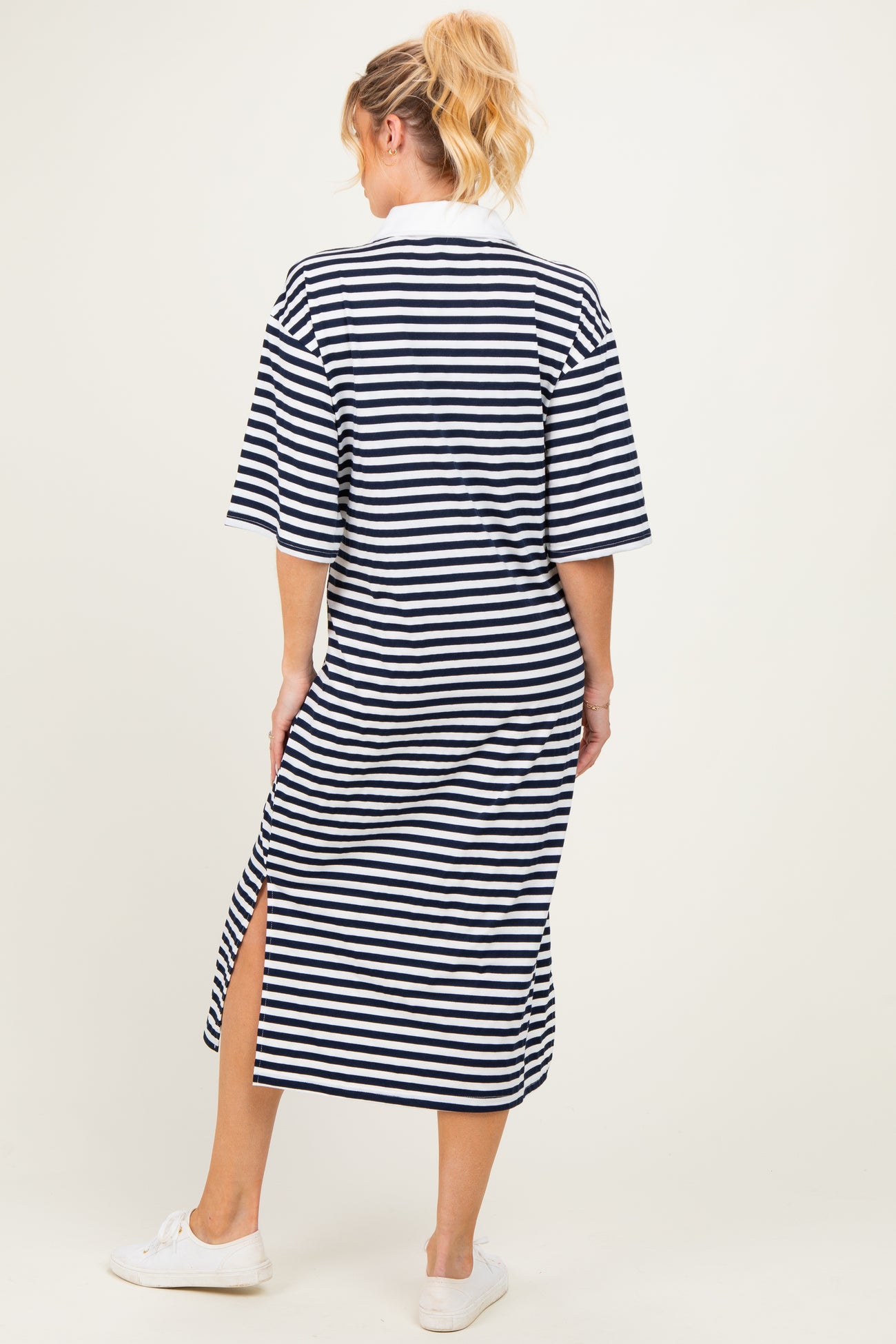 woman wearing a navy and white striped maternity maxi dress with short sleeves and side slits