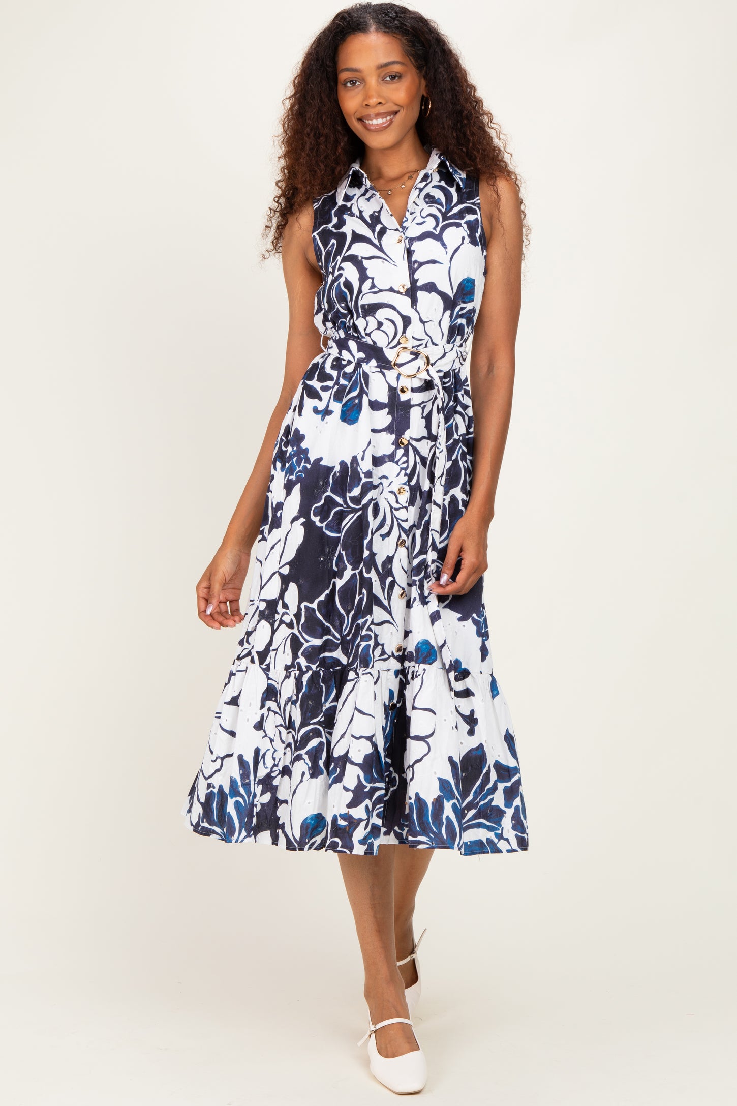 woman wearing a navy blue and white floral midi dress with a fitted bodice and belted waist