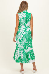 woman wearing a sleeveless green and white floral maternity dress with a flared hemline and back tie detail