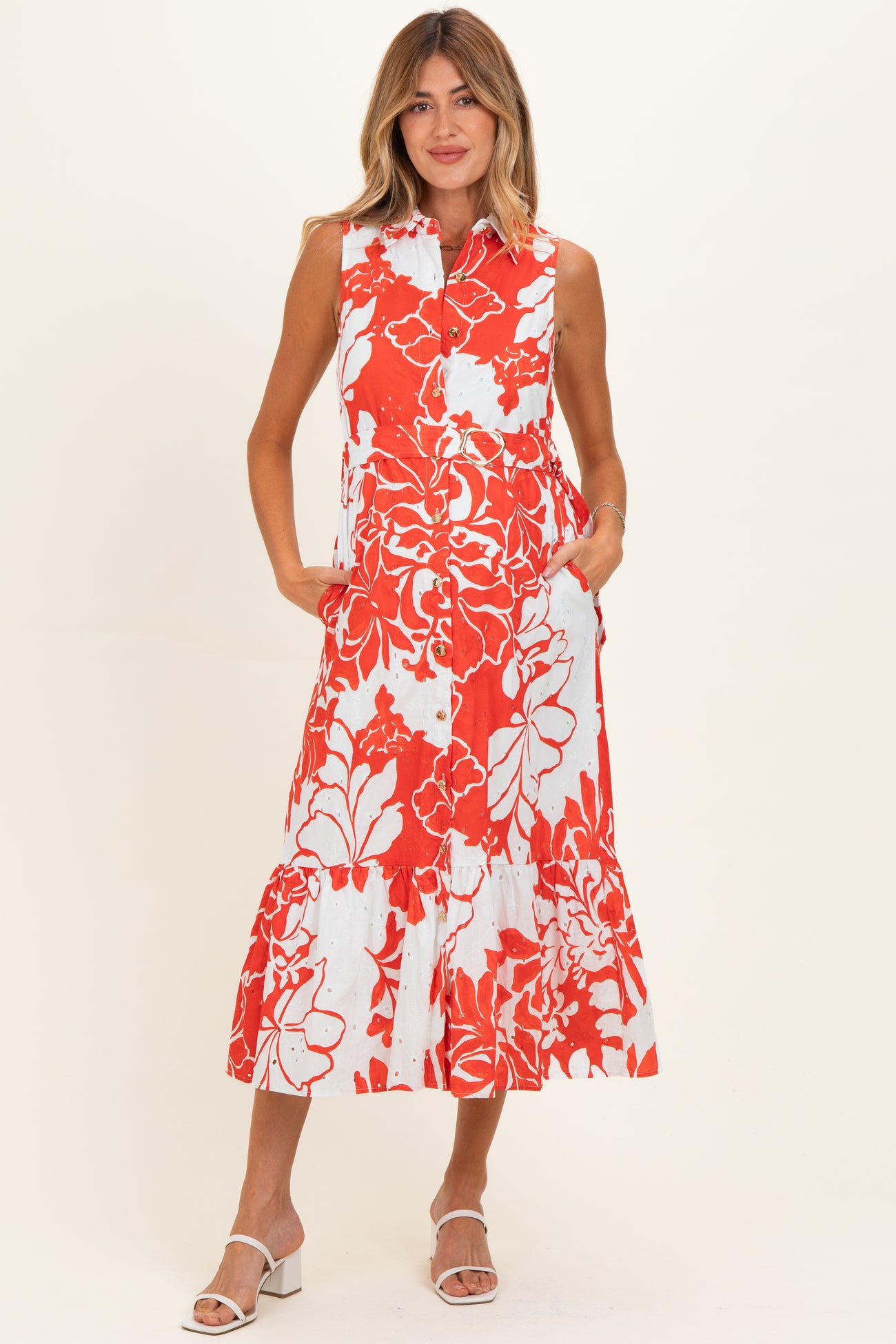 woman wearing a red and white floral sleeveless maternity dress with a tiered skirt and pockets