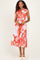 woman wearing a red and white floral midi dress with a collared neckline and a fitted waist