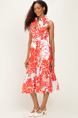 woman wearing a sleeveless red and white floral midi dress with a belt and a ruffled hem