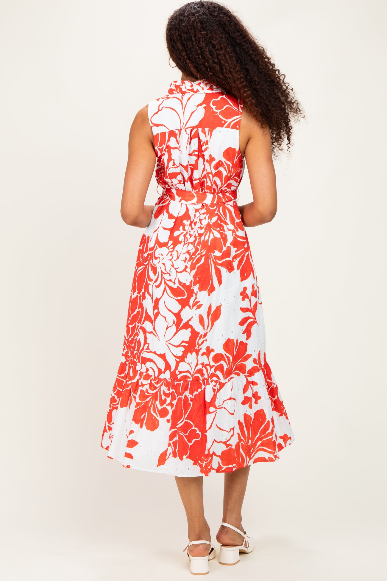 woman wearing a sleeveless red and white floral midi dress with a tiered skirt, shown from the back
