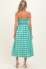 woman wearing a green and white checkered strapless maternity dress with a smocked bodice and flowy skirt