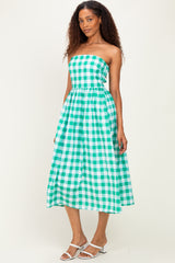 woman wearing a green and white gingham strapless midi dress with a fitted bodice and flowy skirt