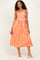 woman wearing an orange and white checkered strapless midi dress with a fitted bodice and flowy skirt