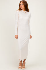 woman wearing a light beige long sleeve midi dress with a fitted silhouette and a slightly frayed hem
