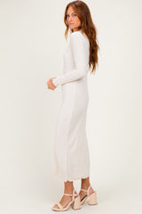 woman wearing a cream long sleeve midi dress with a scalloped hem and paired with heeled sandals