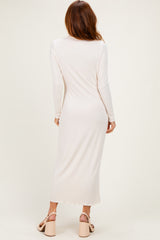 woman wearing a long sleeve light pink maxi dress from the back, paired with chunky heeled sandals