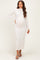 woman wearing a fitted white long sleeve maternity dress with a mock neck and a visible baby bump