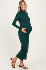 woman wearing a dark green ribbed maternity dress, showcasing her baby bump with a side profile pose