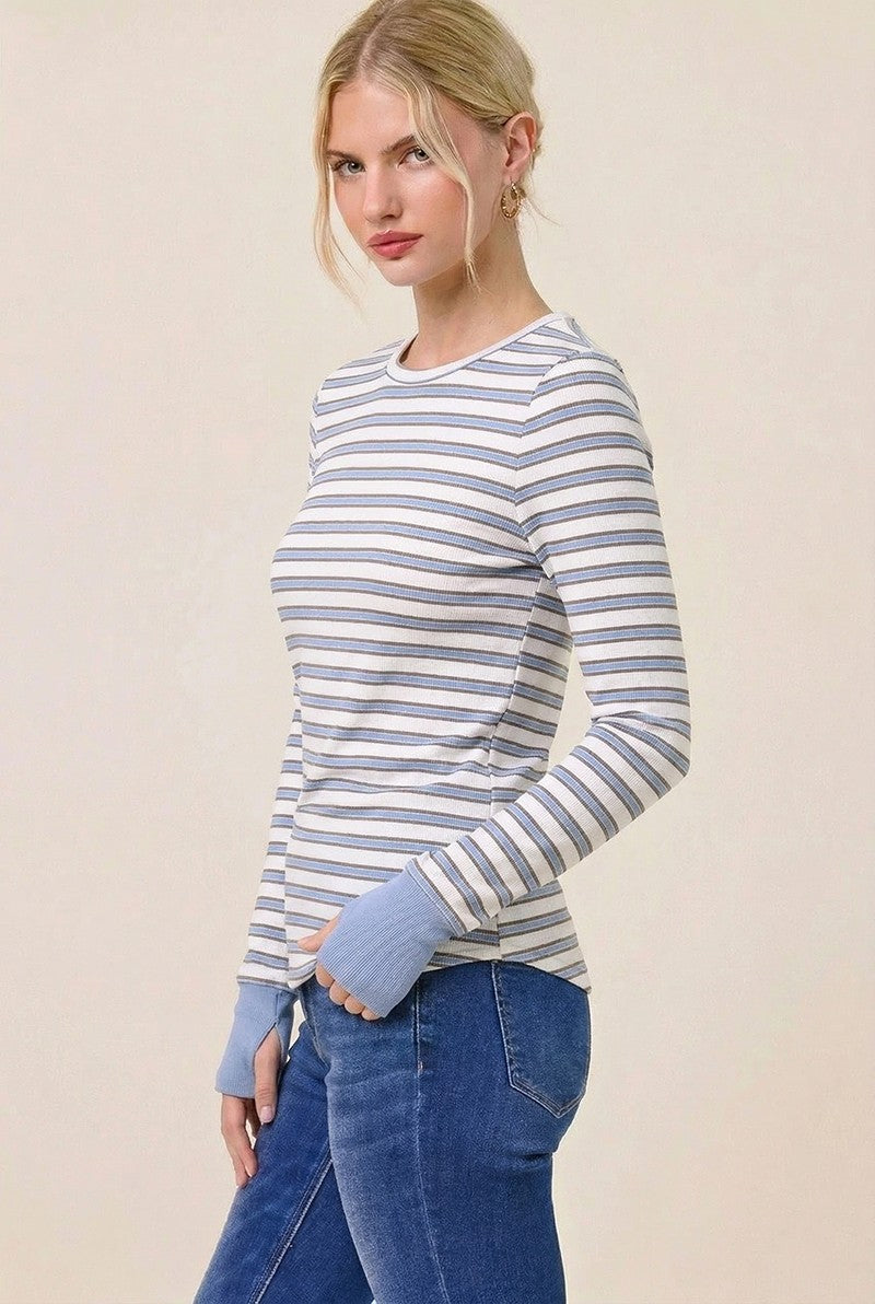 woman wearing a striped long sleeve top in light blue and white paired with high-waisted jeans