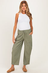 woman wearing a white tank top and green striped maternity pants with pockets and drawstring waist
