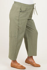 maternity wear olive green striped pants with a drawstring waist and pockets, model showing her baby bump