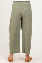 woman wearing olive green striped maternity wide-leg pants, seen from the back