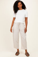 woman wearing a white short sleeve top and light beige wide-leg pants with side pockets and a relaxed fit