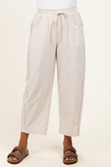 woman wearing light beige cropped wide-leg pants with drawstring waist and side pockets