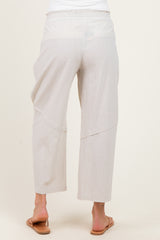 woman wearing light beige maternity pants with a relaxed fit and elastic waistband, viewed from the back