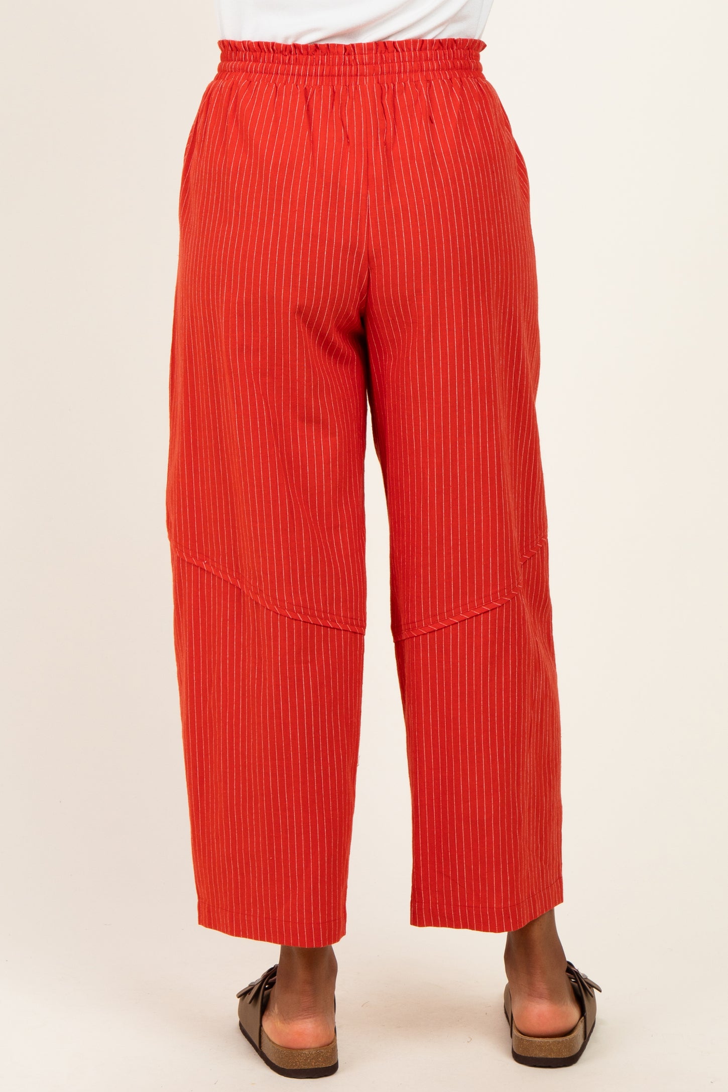 woman wearing red striped wide-leg pants with an elastic waistband, viewed from the back