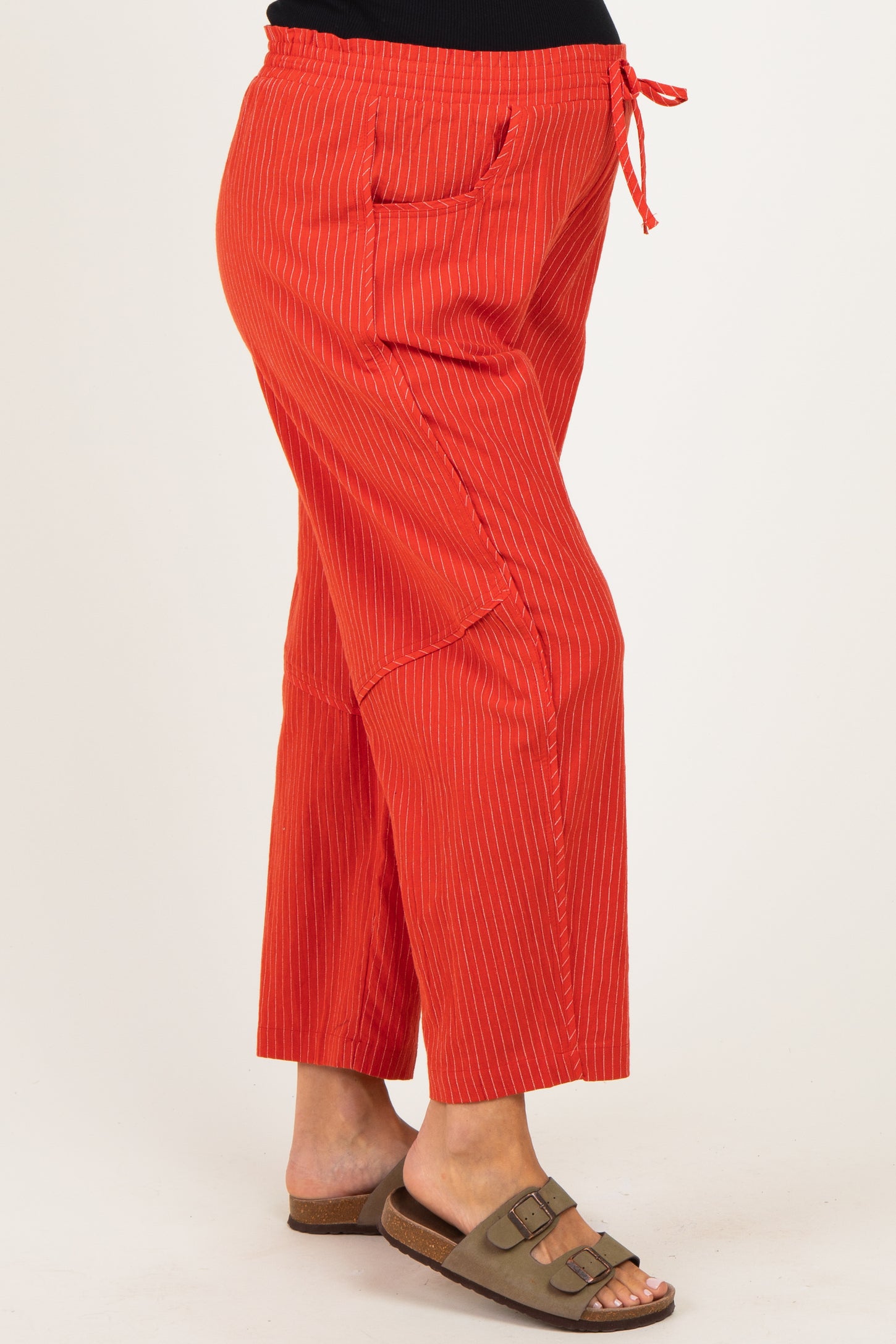 woman wearing a pair of red striped maternity wide-leg pants with a drawstring waist and side pockets