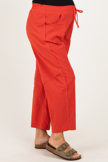 woman wearing a pair of red striped maternity wide-leg pants with a drawstring waist and side pockets
