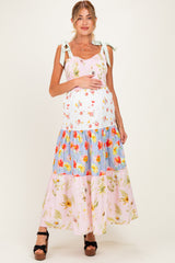 woman wearing a colorful floral maternity maxi dress with adjustable straps and a baby bump