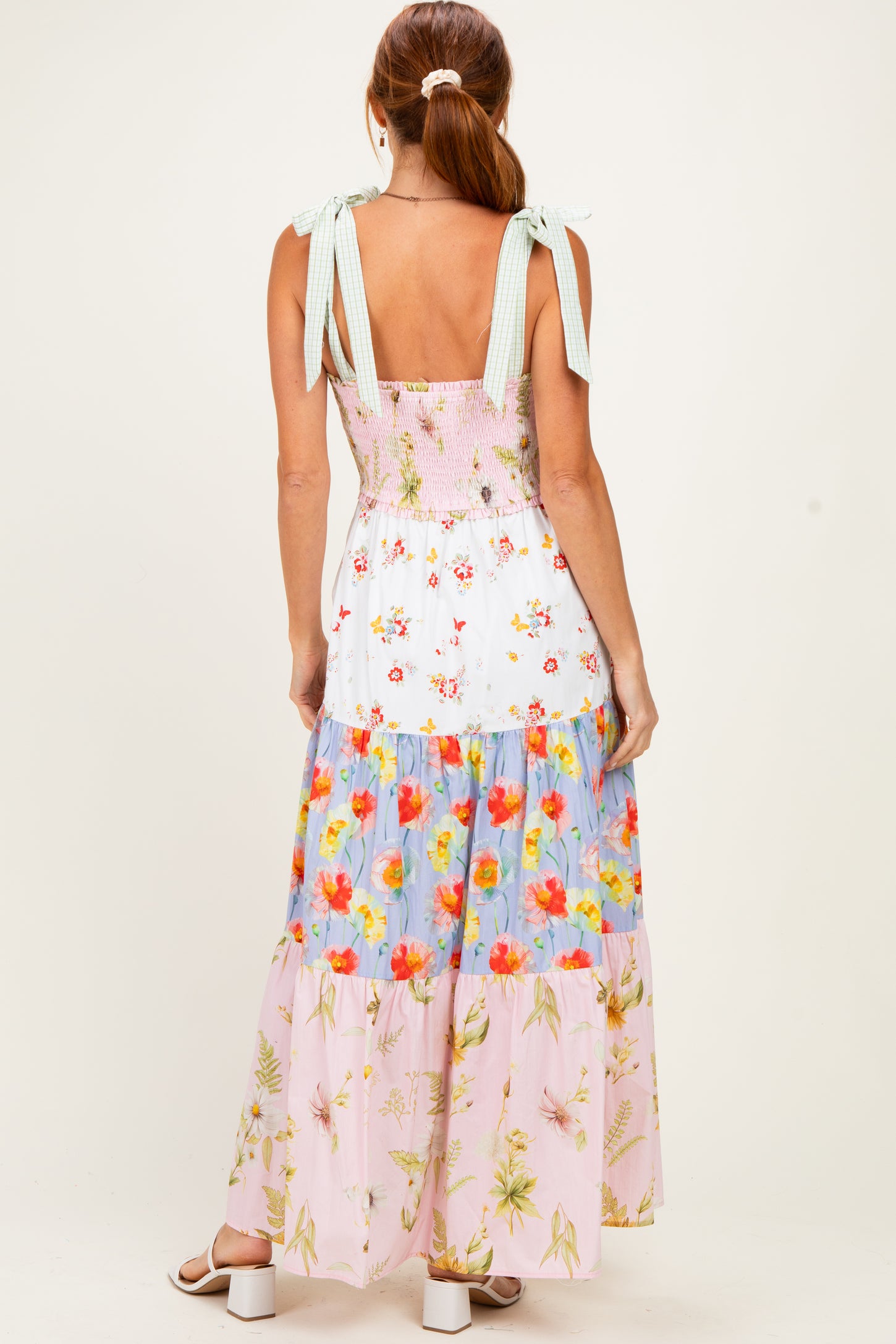 woman wearing a back view of a floral maxi dress with smocked bodice and ribbon straps