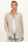 woman wearing a beige and white striped maternity shirt with buttons, showing her baby bump
