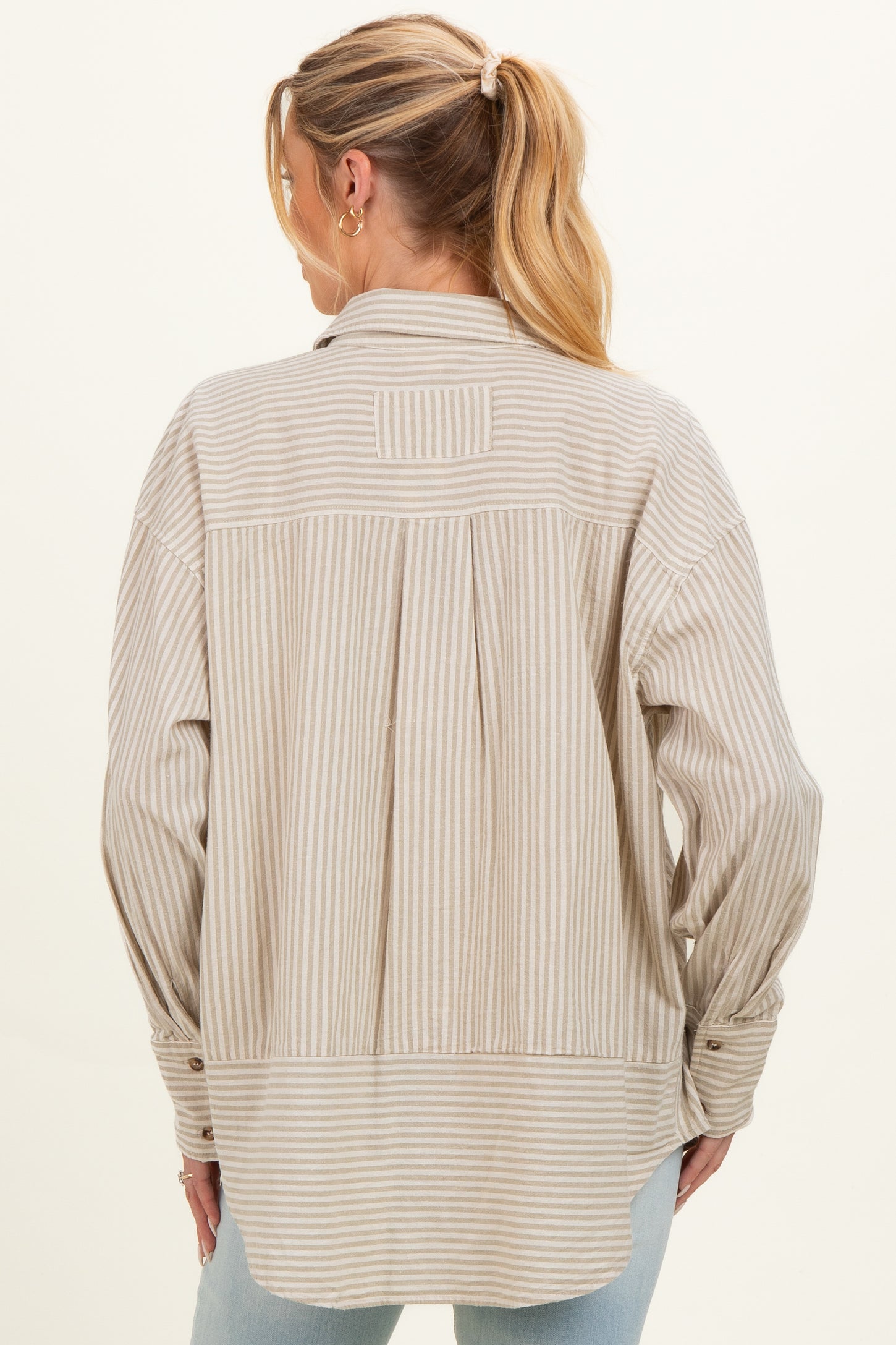 woman wearing a beige striped maternity button-up shirt with a relaxed fit and pleated back detail
