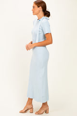 woman wearing a light blue ribbed knit maxi dress with short sleeves and side slits, standing sideways
