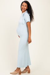 woman wearing a light blue ribbed maternity dress with a bow detail and a visible baby bump
