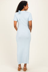 woman wearing a light blue maternity maxi dress with short sleeves and a back bow detail