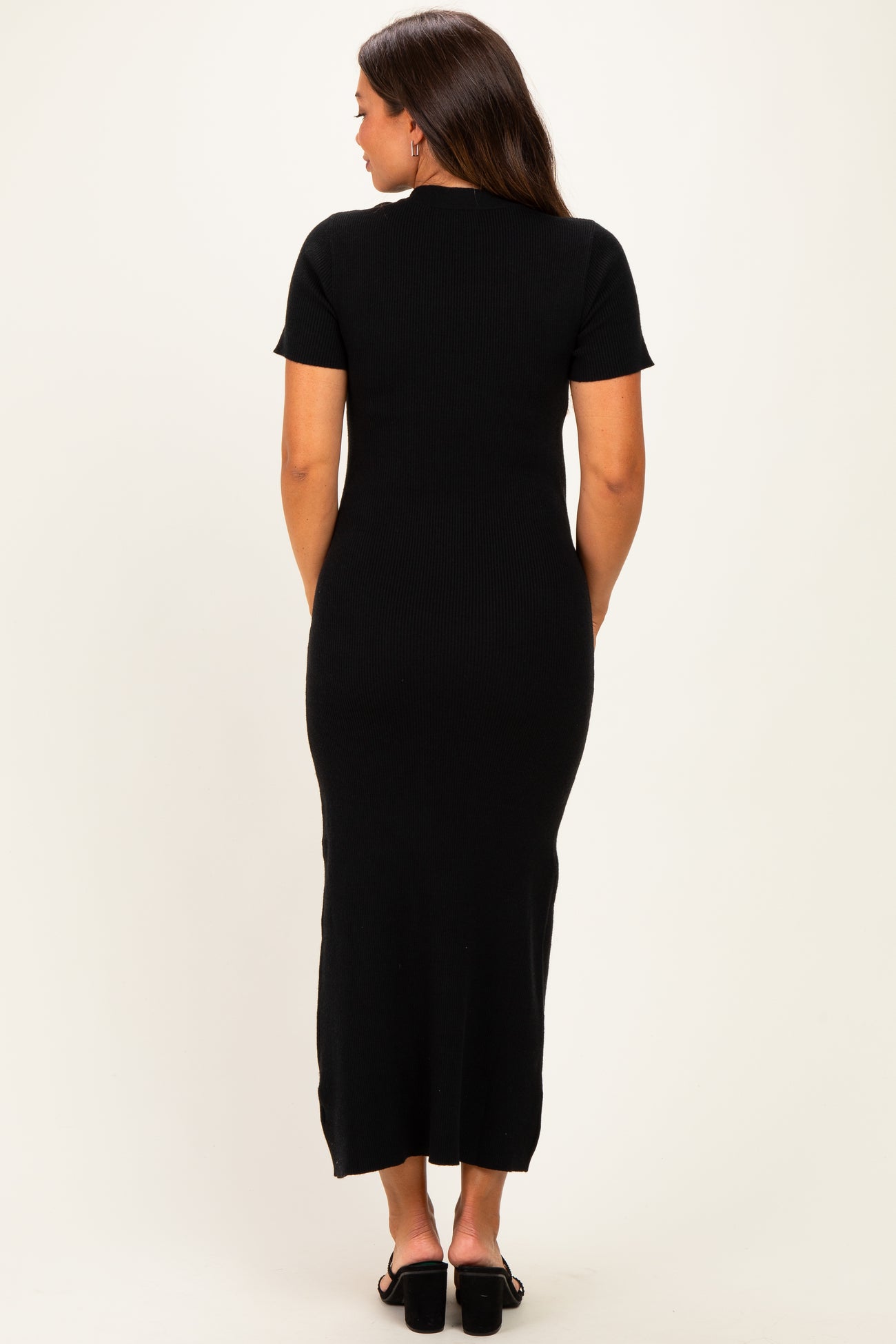 woman wearing a black short sleeve ribbed maternity dress, seen from the back