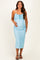 woman wearing a light blue lace maternity dress and showcasing her baby bump