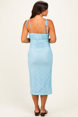woman wearing a light blue maternity dress with adjustable straps and gathered back detail