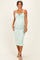 woman wearing a light green maternity dress with adjustable straps and a fitted silhouette, highlighting her baby bump