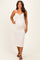 woman wearing a light cream lace maternity dress with adjustable straps and a visible baby bump