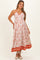 woman wearing a floral maternity maxi dress with a v-neck and halter straps, featuring a tiered skirt and an empire waist