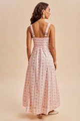 woman wearing a pink floral maxi dress with smocked back and adjustable straps