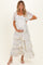 woman wearing a floral tiered maternity maxi dress and holding her baby bump