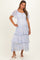 woman wearing a light blue floral maternity dress with tiered layers and short sleeves, showcasing her baby bump