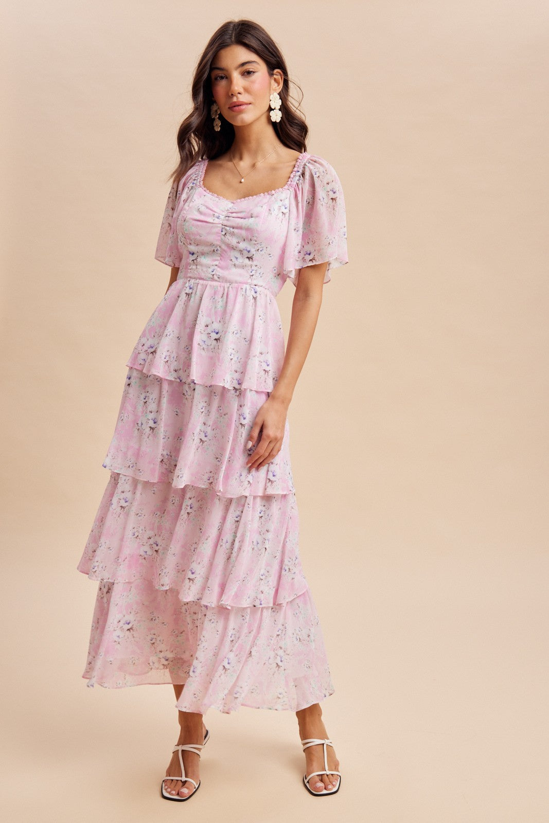 woman wearing a pink floral tiered maxi dress with puff sleeves and square neckline