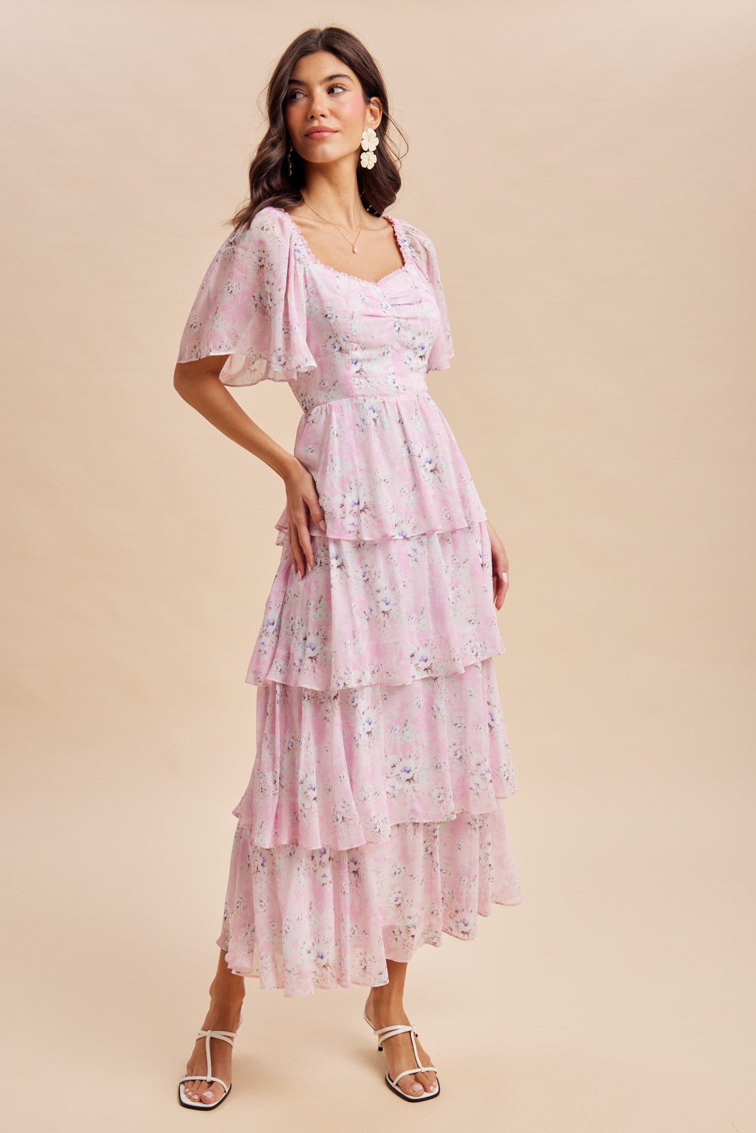 woman wearing a pink floral tiered maxi dress with short sleeves and a square neckline
