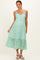 woman wearing a green floral maternity midi dress with ruffled straps and a button-up front
