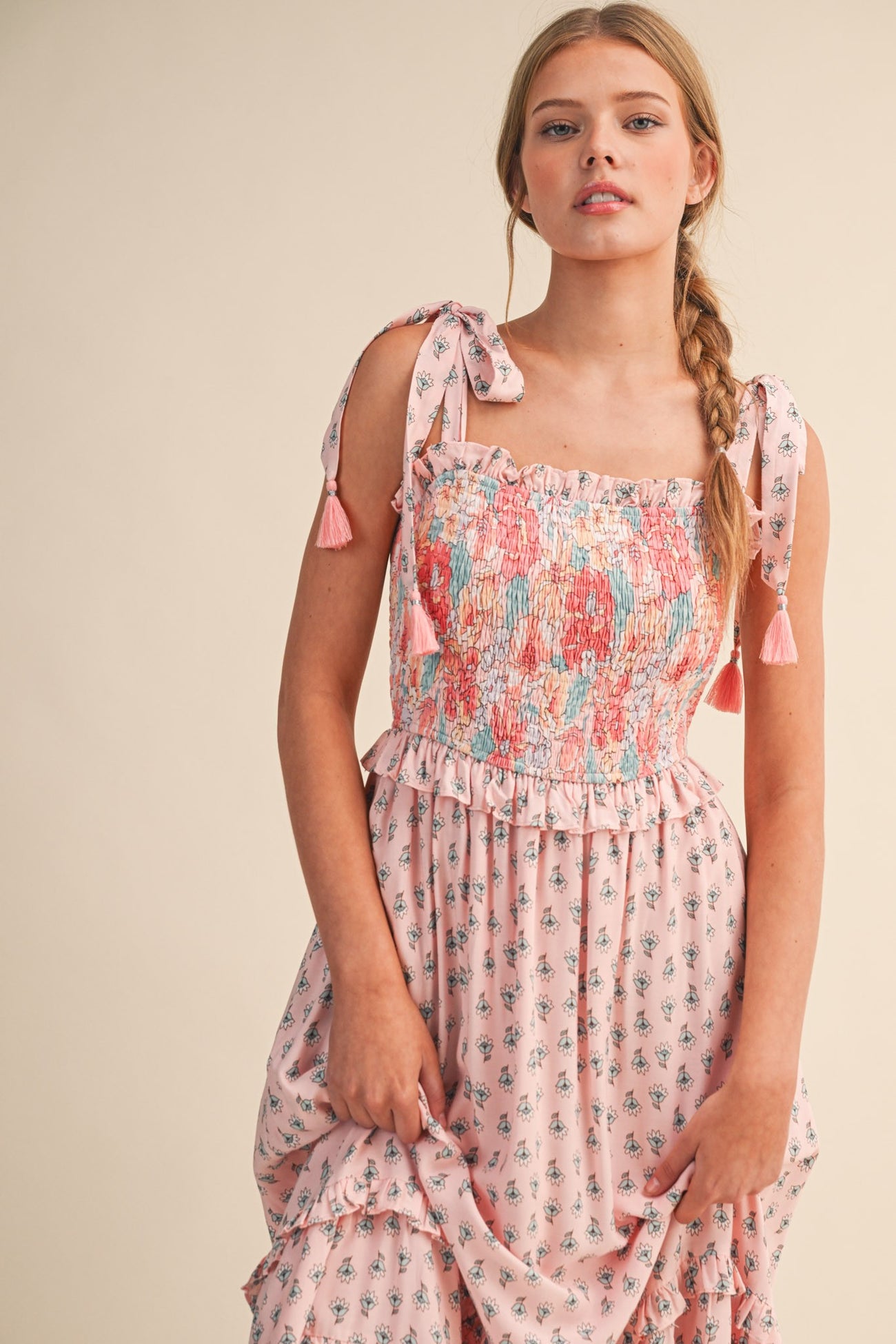 woman wearing a pink floral smocked maxi dress with tie straps and tassels