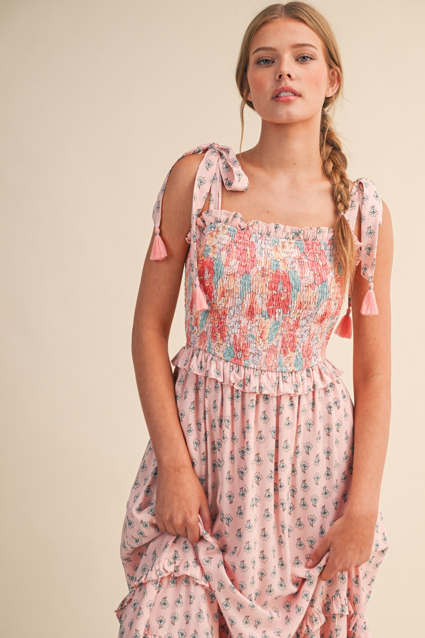 woman wearing a pink floral smocked maxi dress with tie straps and tassels